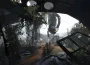 GLaDOS suspendue dans une chambre Aperture envahie par la végétation, screenshot officiel Portal 2