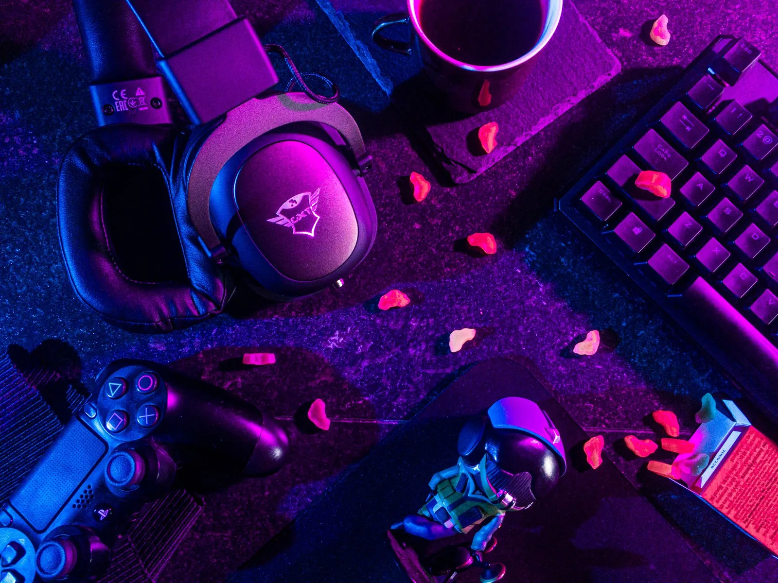 Casque, manette et figurine sous néon violet et bleu